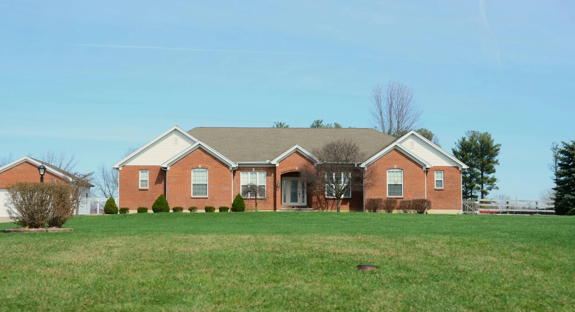 Red brick ranch home on a wide green lawn